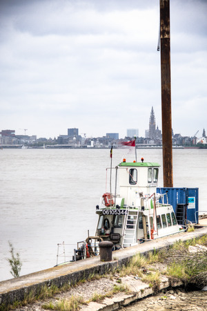 Small boat at the pier in Antwerp Belgium with the city skyline in the backgroundのeditorial素材
