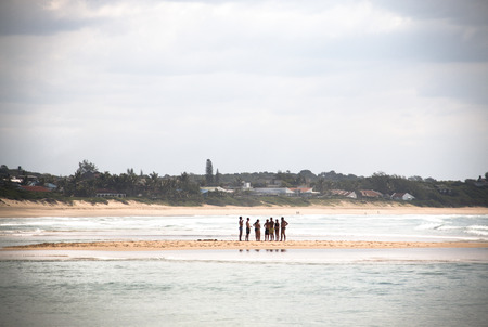 Young people standing on a sand bench in the sea in Punta do Ouro in Mozambiqueのeditorial素材