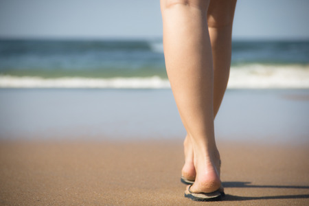 The legs and feet of a girl walking towards the indian ocean in Ponto Do Ouro, Mozambiqueの写真素材