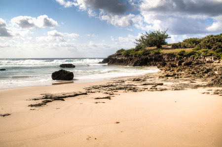 Very rustic and empty beach with large rocks at the Indian Ocean in the coastal town Praia do Tofo in Inhambane, Mozambiqueの写真素材