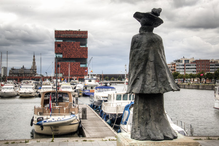 The yacht harbour in the city of Antwerp, Belgium with a statue in the foreground and the MAS museum in the backgroundのeditorial素材