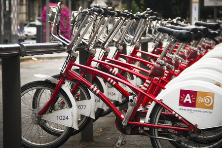 A row of red city bicycles in the center of Antwerp, these bicycles can be rentedのeditorial素材