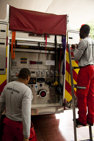 Firemen performing a standard control of the tools in a fire truck