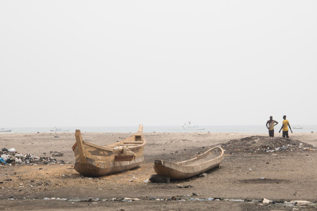ACCRA, GHANA - JANUARY 2016: People and fishing boats on a beach in Jamestown, Accra, Ghana at the Gulf of Guineaのeditorial素材