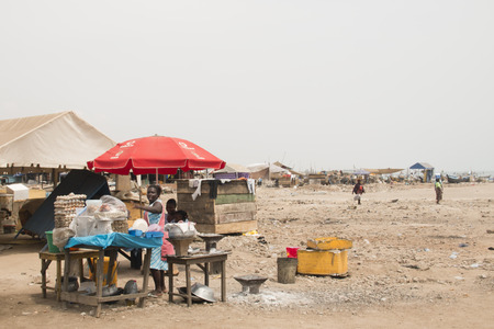 ACCRA, GHANA - JANUARY 2016: Food stall surrounded by people on the beach in Accra, Ghana at the Gulf of Guineaのeditorial素材