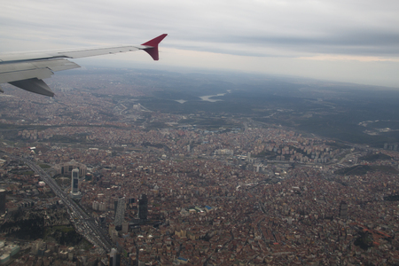 White and red wing of a Turkish Airlines airplane flying over the city of Istanbul in Turkeyの写真素材