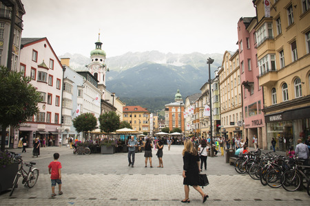 INNSBRUCK, AUSTRIA - JULY 2016: People on the central streat of Innsbruck in Austria with the cathedral and mountains in the backgroundのeditorial素材