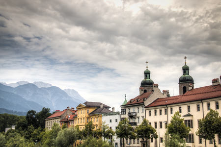 Typical Austrian houses at the embankment of the Inn river in Innsbruck, Austria with the Alps in the backgroundのeditorial素材