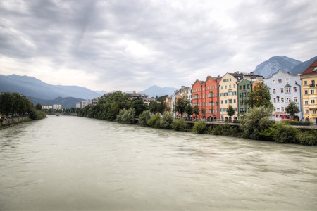Typical Austrian houses at the embankment of the Inn river in Innsbruck, Austria with the Alps in the backgroundのeditorial素材