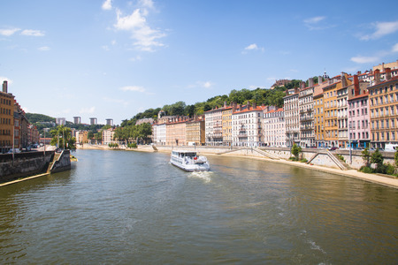 LYON, FRANCE - JULY 2016: Colorful houses on the banks of the Saone river in Lyon, France with a boat passing byのeditorial素材