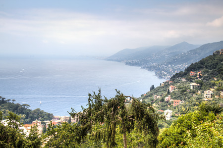 View over the coast and a village in the Liguria area in Italy with mountains in the backの写真素材