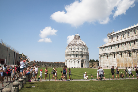 PISA, ITALY - JULY 2016: Tourists next to the basilica of Pisa trying to take photos with the leaning towerのeditorial素材