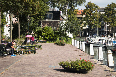 DORDRECHT, NETHERLANDS - OCTOBER 2016: People sitting at the side of a canal in Dordrecht in Holland, Netherlandsのeditorial素材