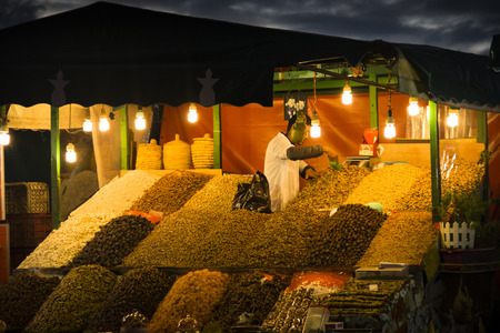 MARRAKESH, MOROCCO - DECEMBER 2016: People during the evening on the very busy main square of Marrakesh in Morocco called Jeema el Fna, with severel food and juice stands and all kinds of visitors and entertainersのeditorial素材