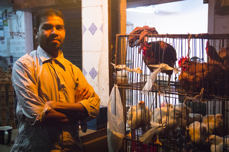 SRIMANGAL, BANGLADESH - FEBRUARY 2017: Man with a small shop selling chicken in the central bazar market in Srimangal, Bangladeshのeditorial素材