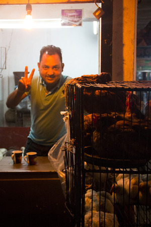 SRIMANGAL, BANGLADESH - FEBRUARY 2017: Man with a small shop selling chicken in the central bazar market in Srimangal, Bangladeshのeditorial素材
