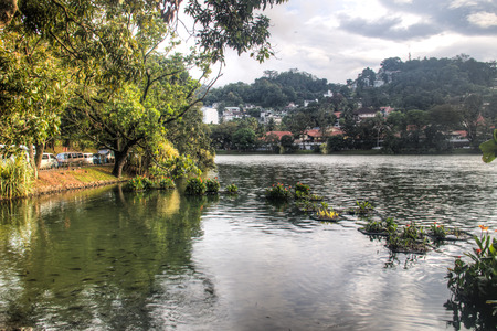 View over the magnificent lake in the centre of Kandy in Sri Lanka, surrounded by hills and housesの写真素材