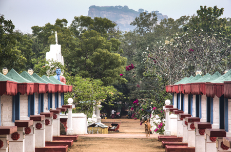 SIGIRIYA, SRI LANKA - DECEMBER 2017: Buddhist temple with huge standing Buddha and any standing monks statues in Sigiriya in Sri Lankaのeditorial素材