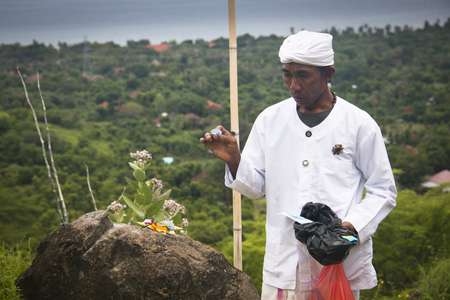 PEMUTERAN, BALI - JANUARY 2018: A hindu priest performing offerings in a temple in Pemuteran in Bali, Indonesiaのeditorial素材