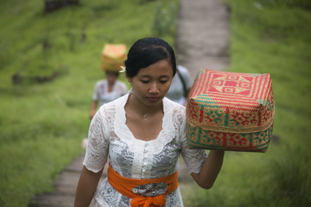 PEMUTERAN, BALI - JANUARY 2018: A group of women in Bali, Indonesia preparing the daily offerings with food and flowersのeditorial素材