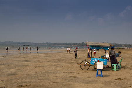 CHAUNG THAR, MYANMAR - MARCH 2018: People on the beach in the coastal town Chaung Thar in Myanmarのeditorial素材