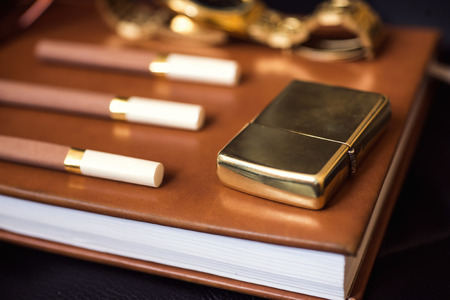 Men accessory, golden lighter, watch and cigarettes on the leather diary.の写真素材