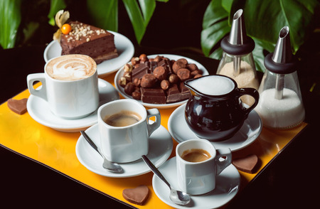 Latte, americano and espresso with brownie and chocolate.の写真素材