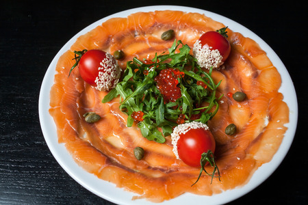 Fish Carpaccio on the black table.の写真素材