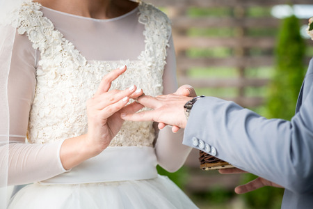 picture of woman putting wedding ring on man's hand.の写真素材