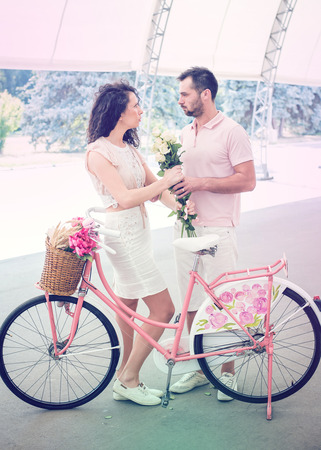 Couple with pink vintage bicycle in the summer park. Outdoor shot.の写真素材