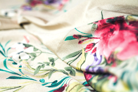 Beautiful satin textile with flowers on wooden background.の写真素材