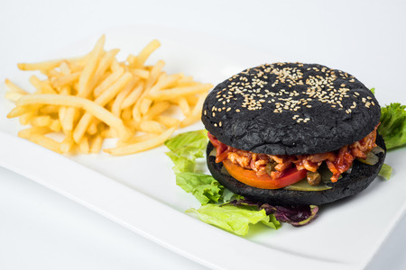 Delicious black hamburger and fries on white .の写真素材