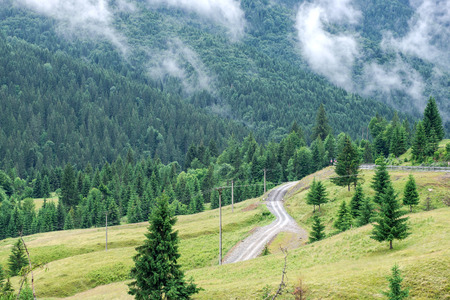 Road through mountains under a cloudy sky in sunny day.の写真素材