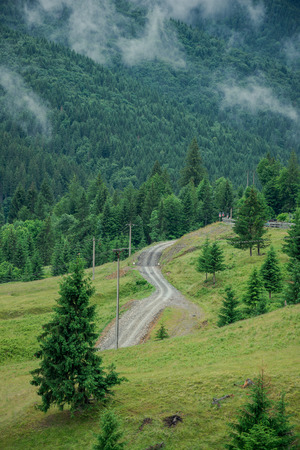 Road through mountains under a cloudy sky in sunny day.の写真素材