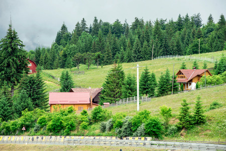Traditional wooden mountain house on green field in summer.の写真素材