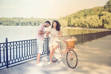 Couple with pink vintage bicycle in the summer park on a sunsetの写真素材