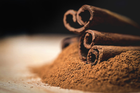 Cinnamon sticks with cinnamon powder on wooden background,の写真素材