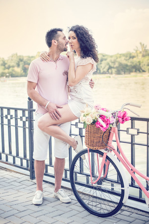 Couple with pink vintage bicycle in the summer park on a sunsetの写真素材