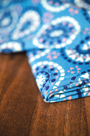 blue fabric textile with ornament on wooden background.