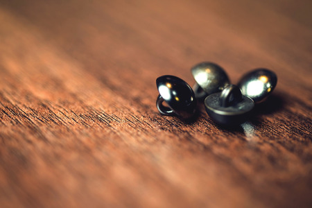 Vintage metal buttons on wood floor background.の写真素材