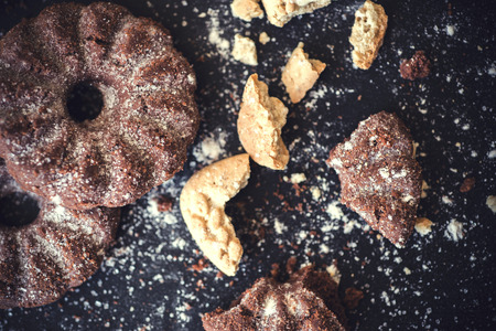 Different cookies on black chalkboard from above