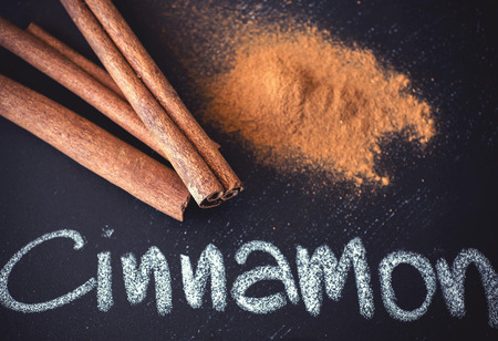 Cinnamon sticks on black chalkboard from aboveの写真素材