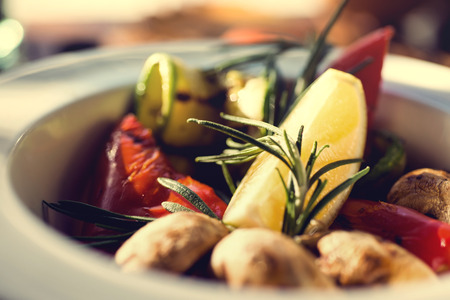 fresh salad with tomatoes, mushrooms, lemon and rosemary on the plate wooden table. Autumn concept.の写真素材