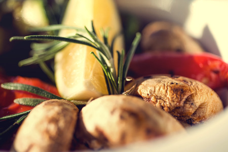 fresh salad with tomatoes, mushrooms, lemon and rosemary on the plate wooden table. Autumn concept.の写真素材