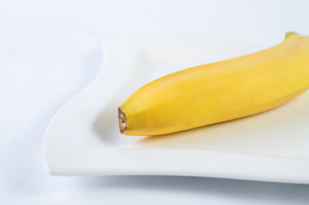 One banana on plate. white background.の写真素材