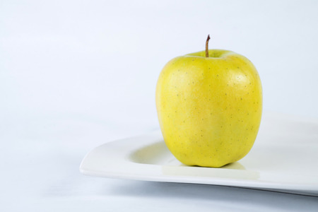 Green Apple on plate. white background.の写真素材