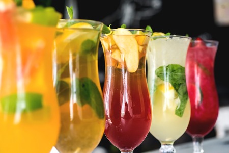 Different cold refreshing cocktails on wooden table. Selective focusの写真素材