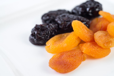 dried apricots and prunes on a white background.の写真素材