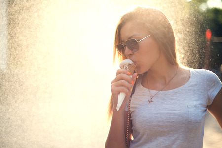 Woman eating a delicious ice cream on the sunset.の写真素材