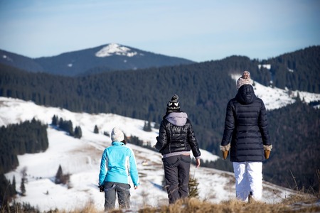 Three girls enjoying mountain view together in wintertime. Mountain backgroundの写真素材